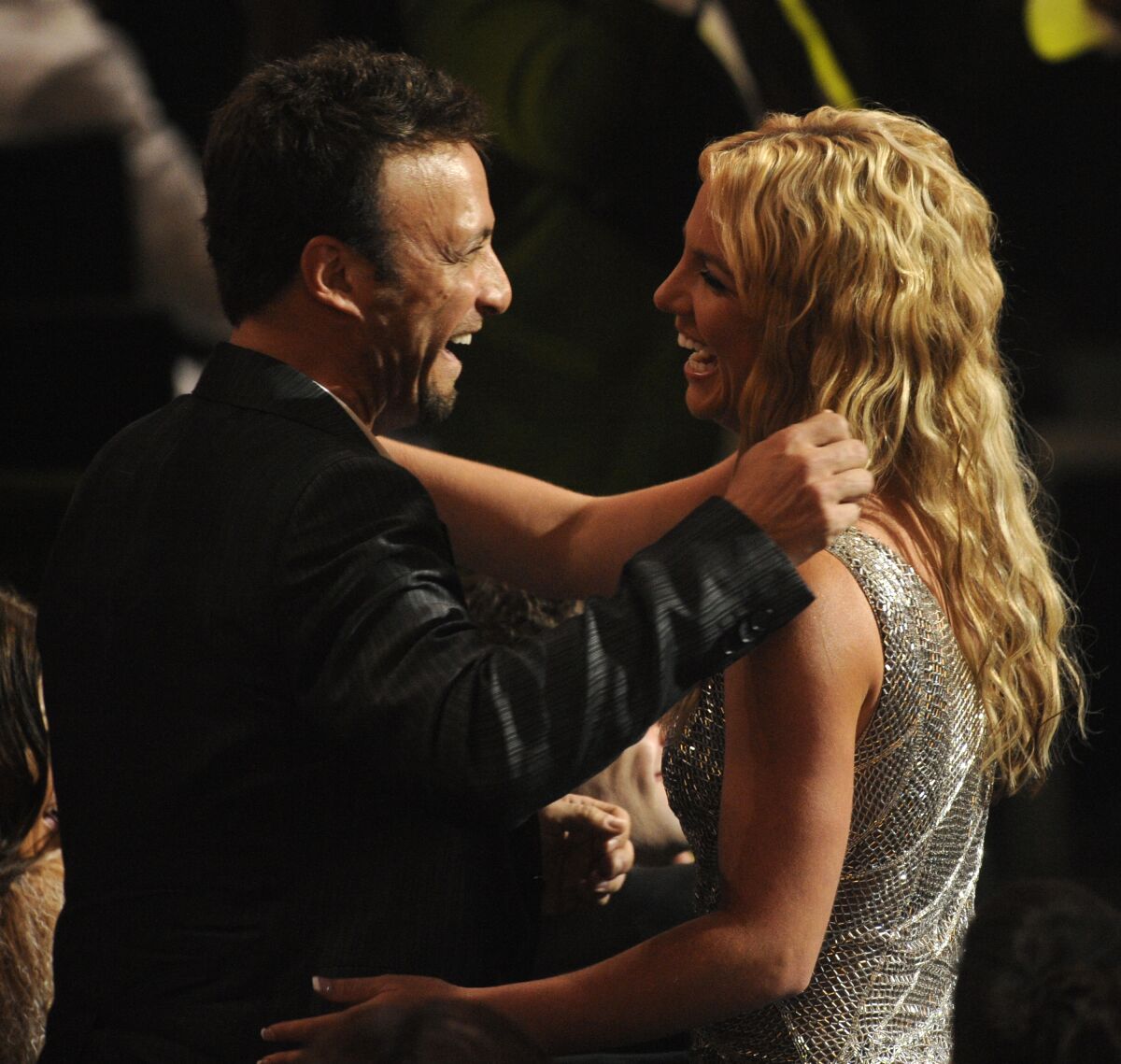 A man congratulates a smiling woman