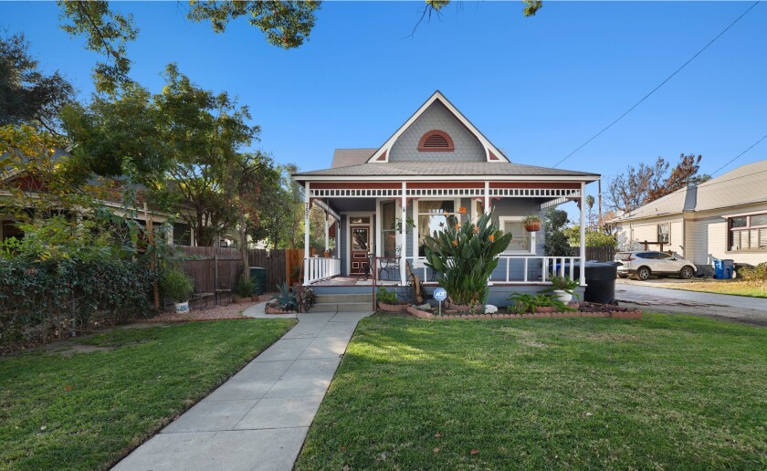 A Victorian home with a wraparound porch in Pomona