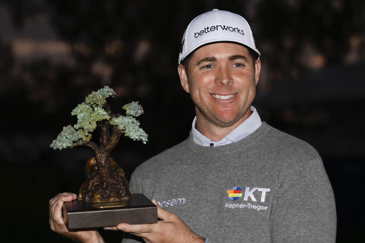 Luke List holds the championship trophy after winning the Farmers Insurance Open on Jan. 29, 2022.