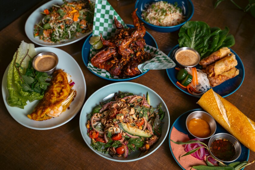 An aerial shot of a variety of dishes, including chicken wings, banh mi and banh cuon.