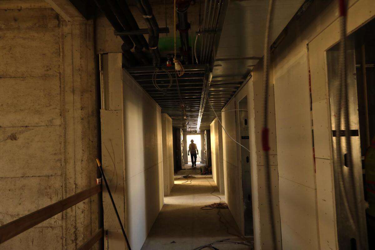 A construction worker walks down a hallway inside a building