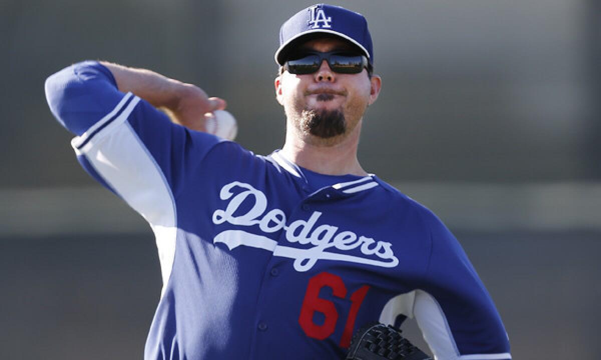 Dodgers pitcher Josh Beckett throws during a spring training practice session. A sprained thumb could force Beckett to miss his scheduled exhibition start Friday.