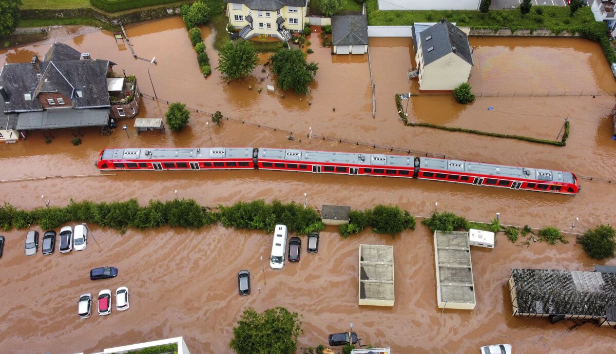 FILE - In this Thursday, July 15, 2021, 2021 file photo, a regional train in the flood waters at the local station in Kordel, Germany, after it was flooded by the high waters of the Kyll river. This summer a lot of the places hit by weather disasters are not used to getting extremes and many of them are wealthier, which is different from the normal climate change victims. That includes unprecedented deadly flooding in Germany and Belgium, 116-degree heat records in Portland, Oregon and similar blistering temperatures in Canada, along with wildfires. Now Southern Europe is seeing scorching temperatures and out-of-control blazes too. And the summer of extremes is only getting started. Peak Atlantic hurricane and wildfire seasons in the United States are knocking at the door. (Sebastian Schmitt/dpa via AP, File)