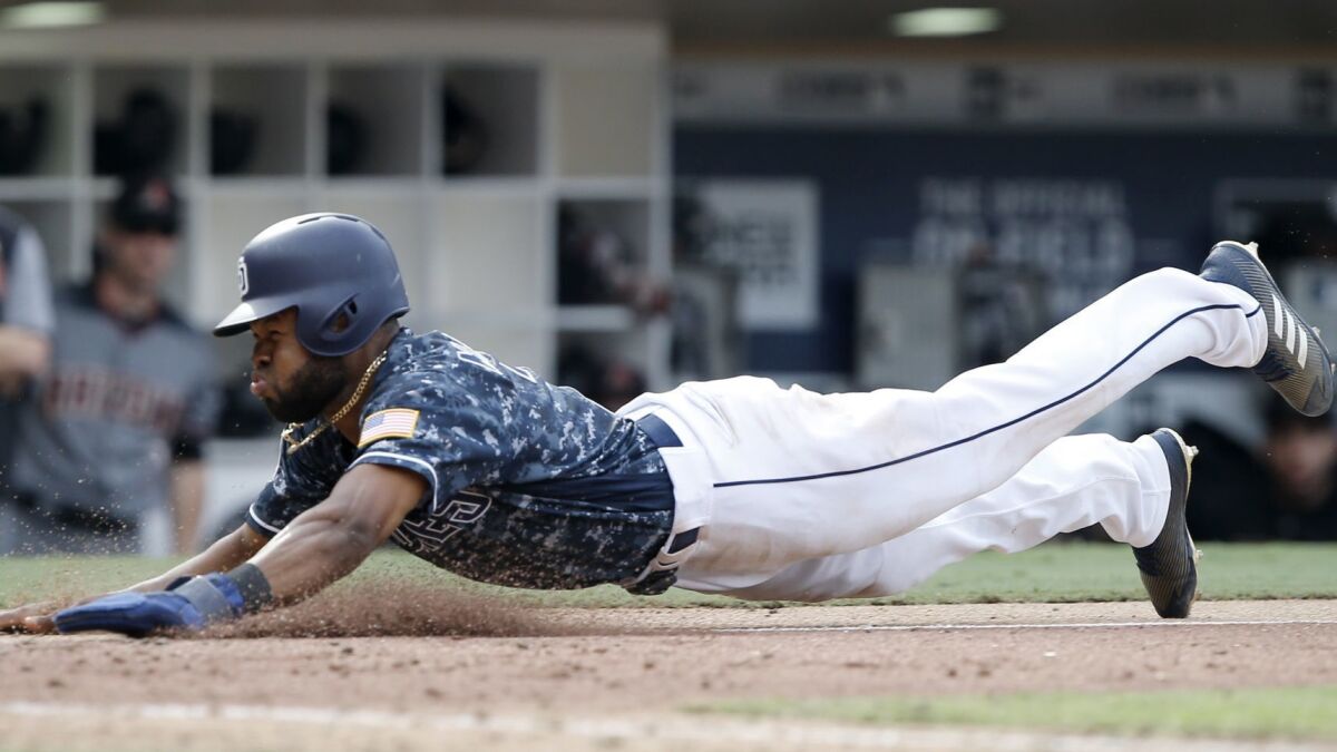 The Padres' Manuel Margot slides into home safely after Arizona Diamondbacks catcher John Ryan Murphy threw to first to get Francisco Mejia, after striking out swinging, during the 10th inning of a baseball game in San Diego, Sunday, Sept. 30, 2018.