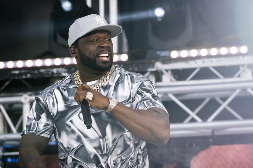 Rapper 50 Cent looks off to his left while performing onstage