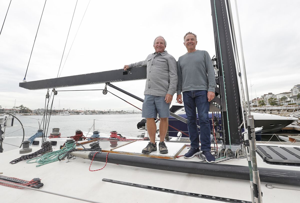 Tim and Buddy Richley, from left, stand on racing boat Amante in Newport Harbor.
