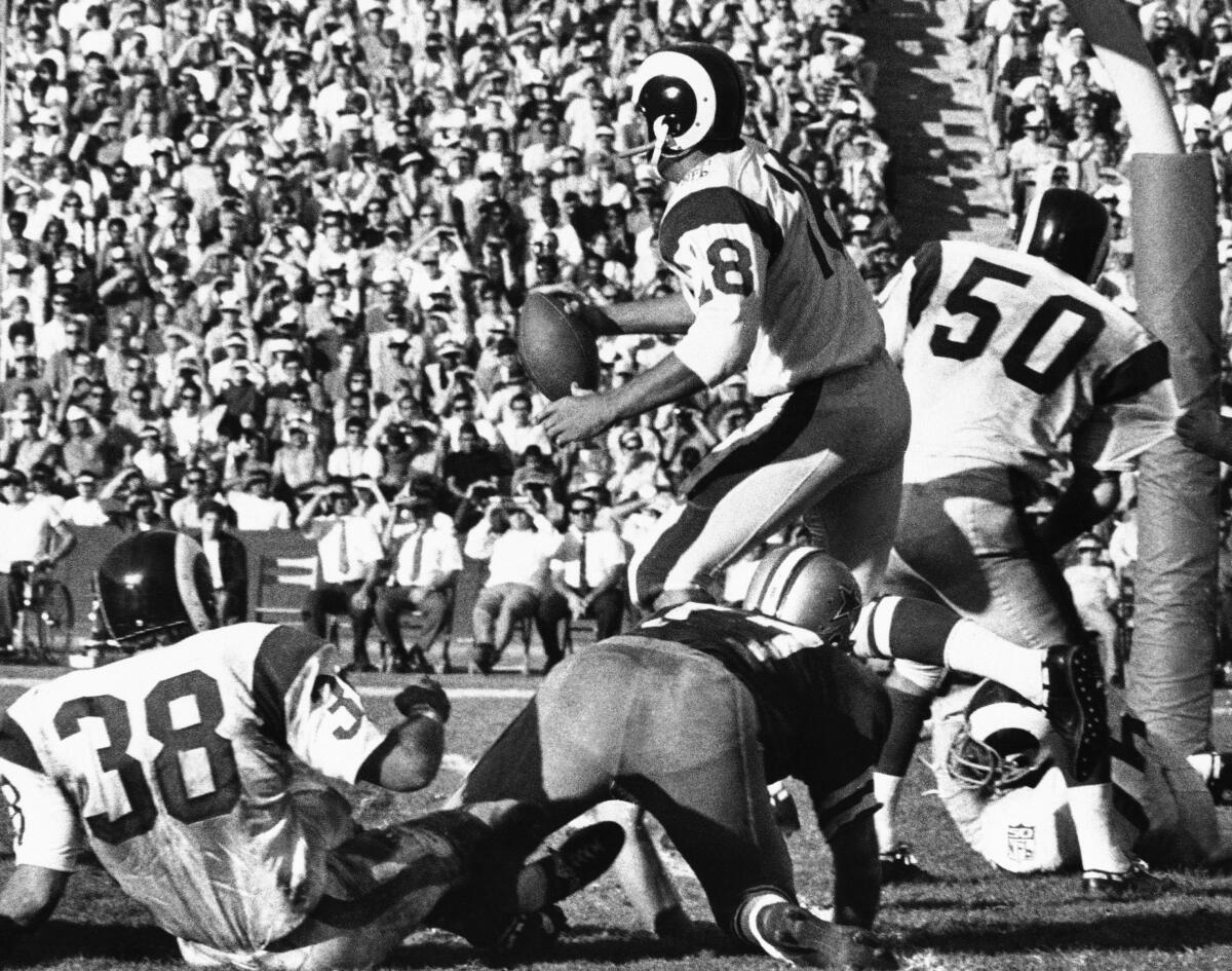 Los Angeles Rams quarterback Roman Gabriel (18) narrowly escaped being tackled during a game with Dallas Cowboys 
