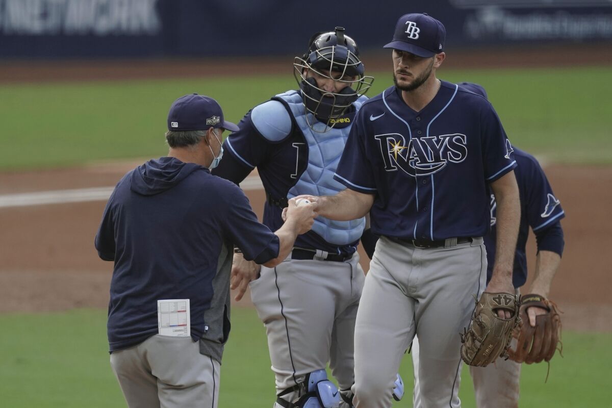 Tampa Bay Rays starting pitcher Ryan Thompson, right, hands the ball to manager Kevin Cash, left, as he is pulled during the second inning in Game 4 of a baseball American League Division Series against the New York Yankees, Thursday, Oct. 8, 2020, in San Diego. (AP Photo/Jae C. Hong)