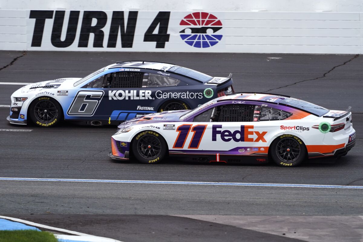 Denny Hamlin (11) chases Brad Keselowski (6) through Turn 4 during a NASCAR Cup Series auto race at the New Hampshire Motor Speedway, Sunday, July 17, 2022, in Loudon, N.H. (AP Photo/Charles Krupa)