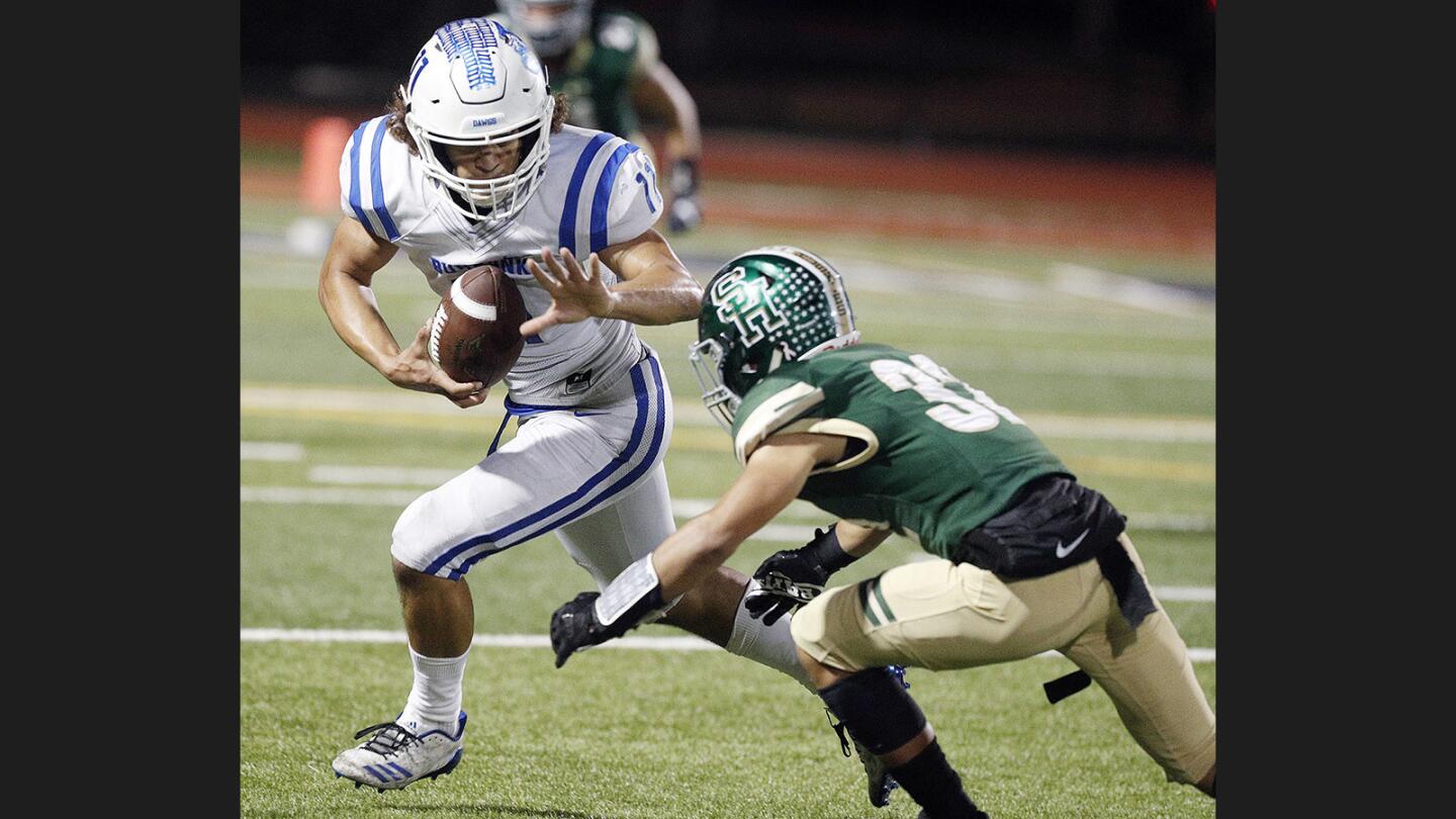 Burbank's Drew Pendleton, after a catch, reaches out to attempt to prevent being tackled by South Hill's Alex Rodriguez in a CIF quarterfinal football game at Covina Field in Covina on Friday, November 17, 2017. Burbank won the game 42-30.