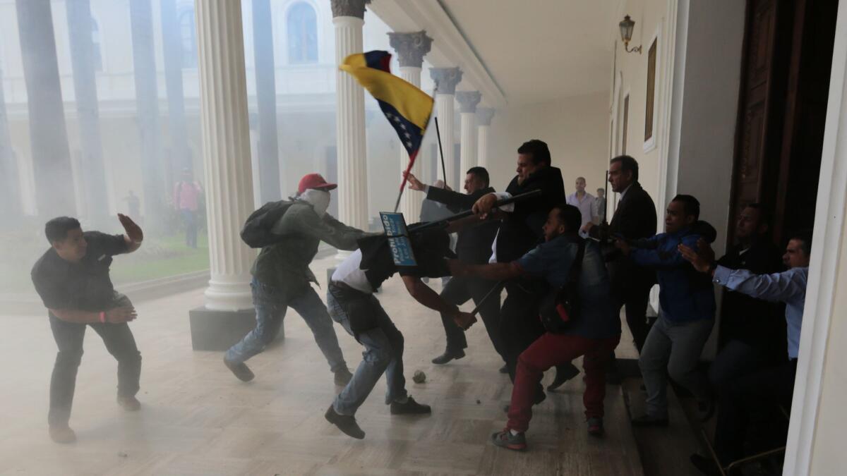 Opposition lawmakers brawl with pro-government militias trying to force their way into the National Assembly during a special session in July.