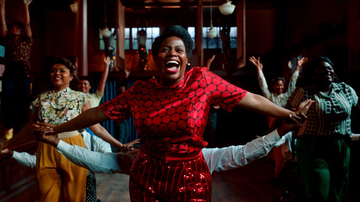 Fantasia Barrino as Celie leads a joyous dance in a bright red dress in "The Color Purple." 