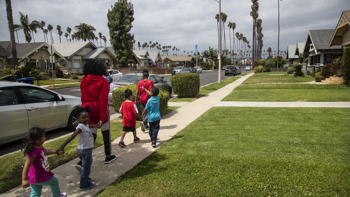 Sandra Pruitt escorts kids she babysits to a park near her Jefferson Park home in Los Angeles. As housing costs rise sharply, Pruitt worries longtime residents will be forced out.