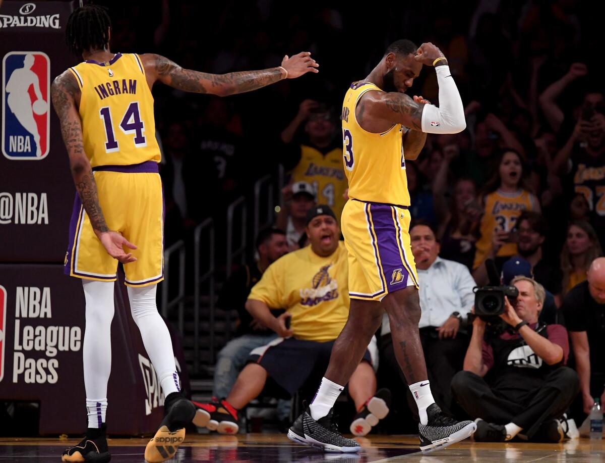 LeBron James #23 of the Los Angeles Lakers celebrates his dunk in front of Brandon Ingram #14 during a preseason game against the Denver Nuggets at Staples Center on October 2, 2018 in Los Angeles, California.