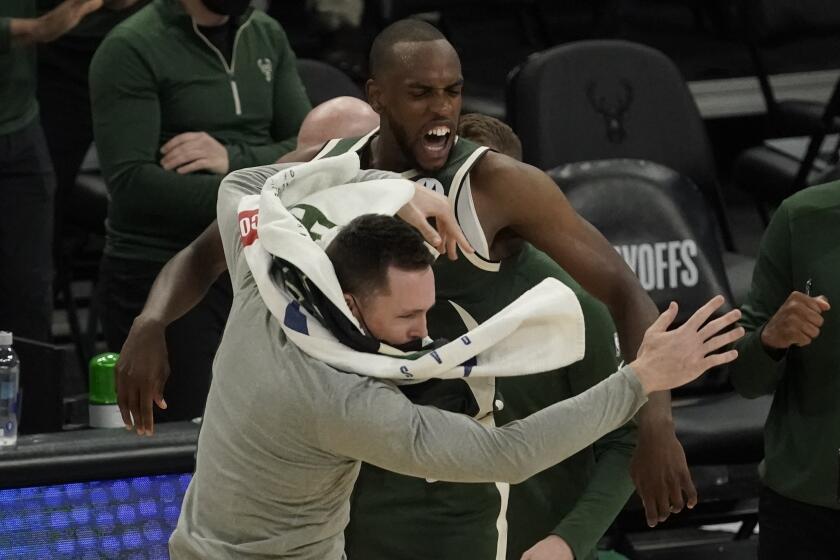 Milwaukee Bucks' Khris Middleton celebrates with teammate Pat Connaughton after making a basket in the final seconds of overtime of Game 1 of their NBA basketball first-round playoff series against the Miami Heat Saturday, May 22, 2021, in Milwaukee. The Bucks won 109-107 to take a 1-0 lead in the series. (AP Photo/Morry Gash)