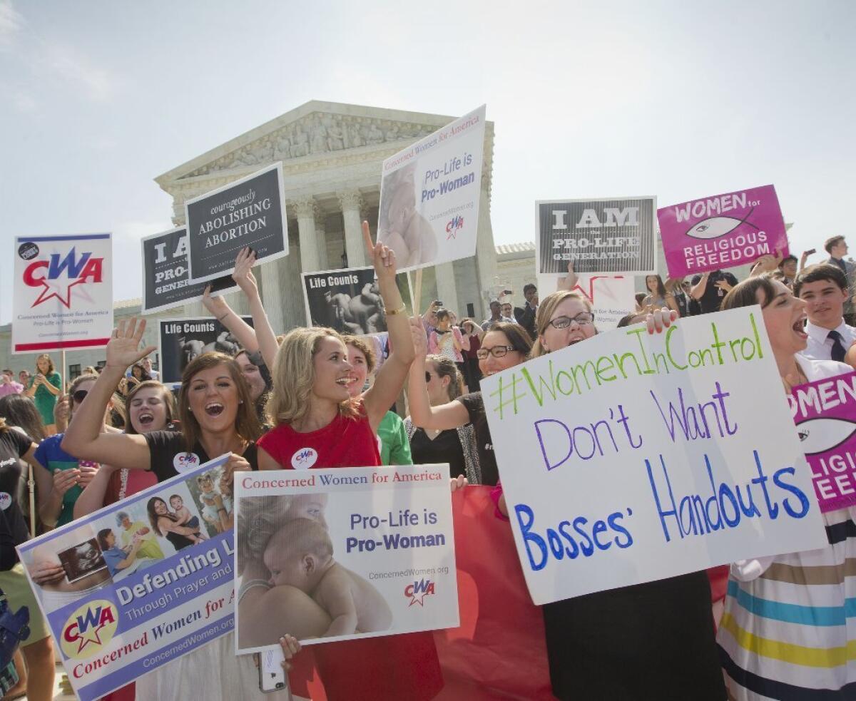 Demonstrators in Washington react to the U.S. Supreme Court's decision Monday on the contraceptive mandate for employers voicing religious objections.
