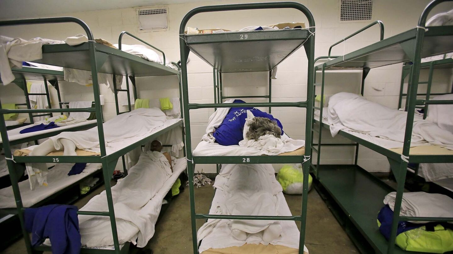 An inmate sleeps in a triple bunk dorm room inside the Men's Central Jail. In Los Angeles County, with a quarter of California's jail population, male inmates often are released after serving as little as 10% of their sentences and female prisoners after 5%.