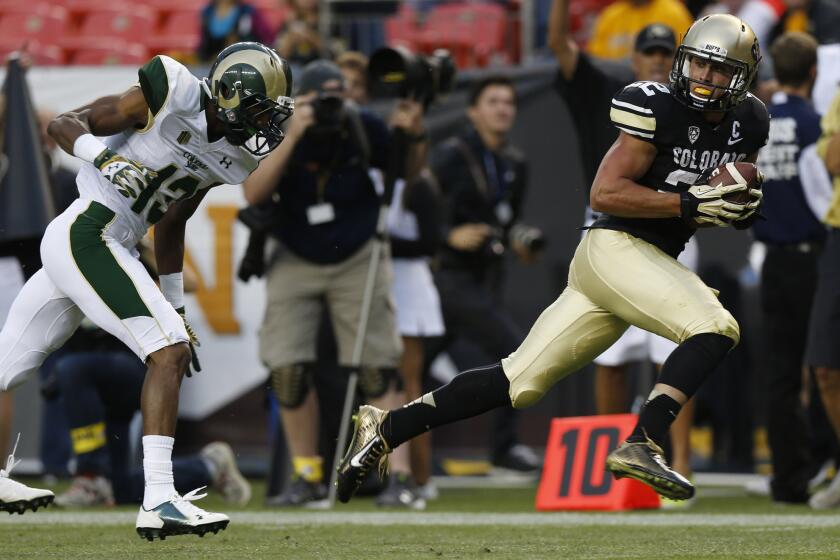 Colorado wide receiver Nelson Spruce, right, runs for the goal line after pulling in a pass for a 54-yard touchdown, beating Colorado State defensive back DeAndre Elliott in the first quarter on Aug. 29, 2014.