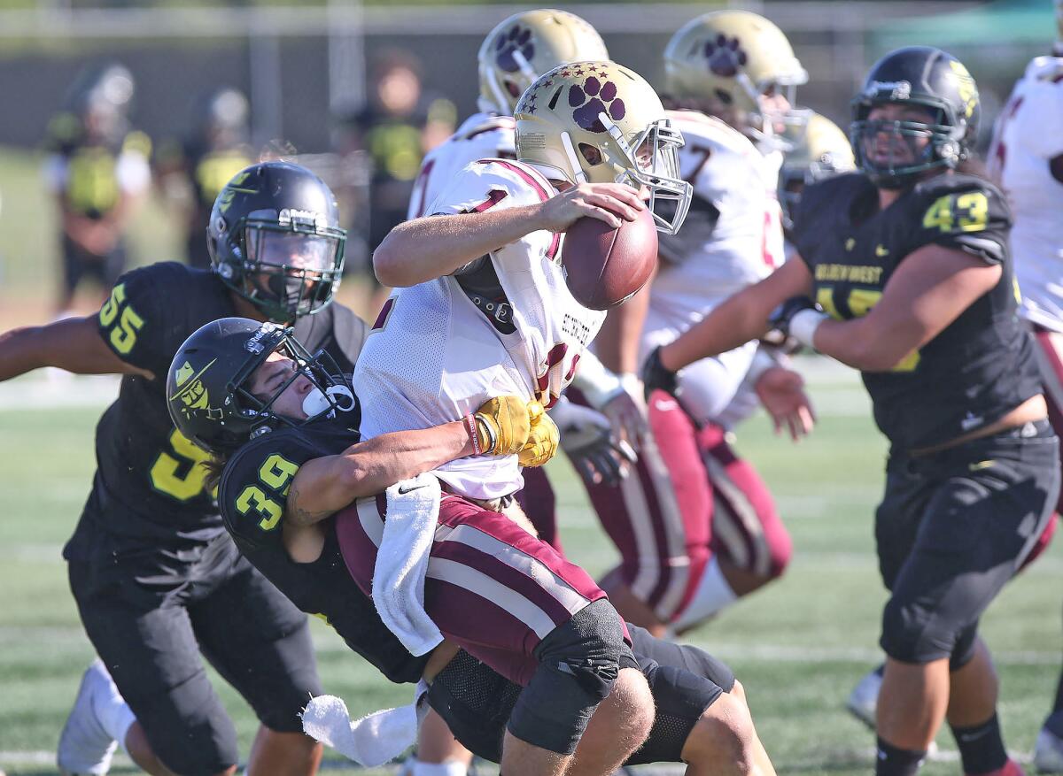 Golden West College's Pablo Araya (39) takes down quarterback Joshua Owen during a nonconference game against Southwestern on Saturday.