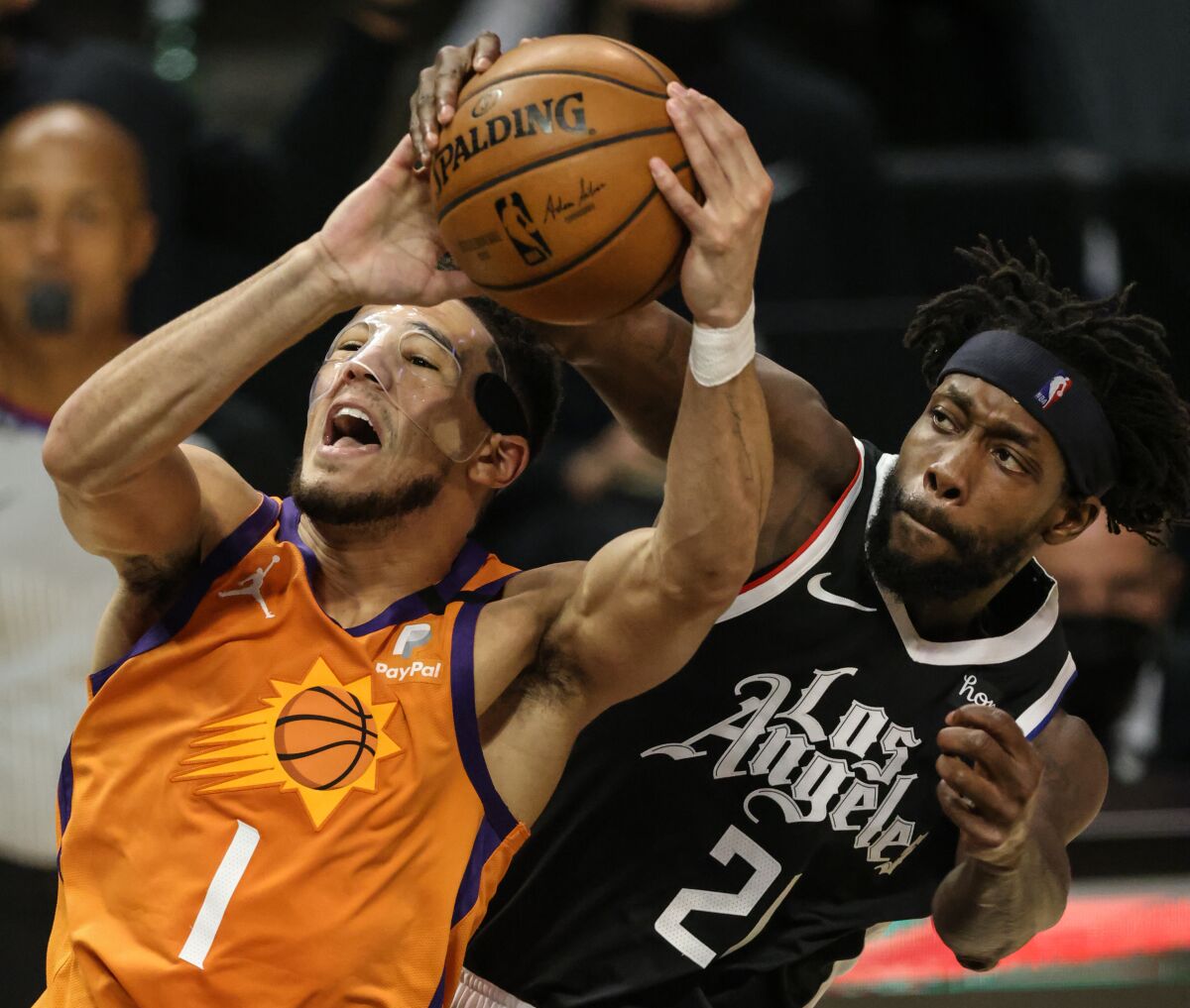 Clippers guard Patrick Beverley fouls Suns guard Devin Booker on a shot attempt.
