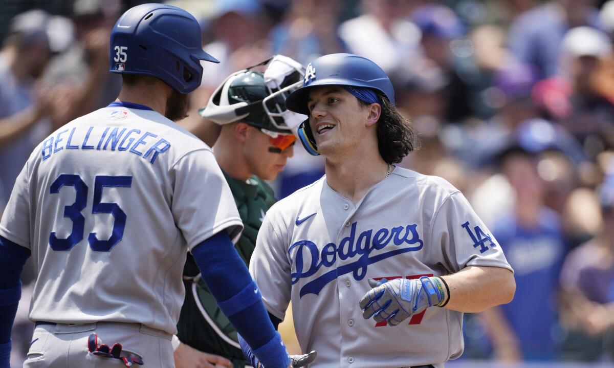 Cody Bellinger of the Dodgers congratulates James Outman as he crosses home plate.