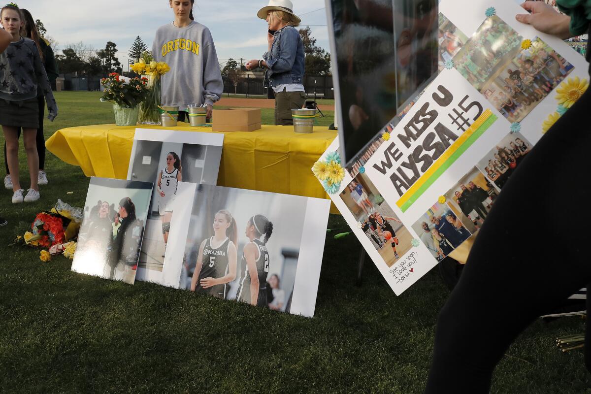 Photos of Alyssa Altobelli are set out as part of a makeshift memorial in honor of her on Thursday evening at Mariners Park in Newport Beach.
