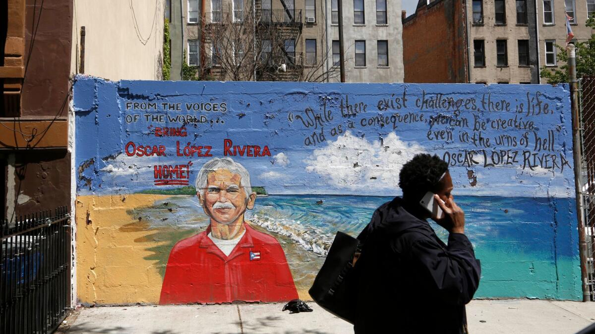 A man walks past a mural of Oscar Lopez Rivera in New York on May 9.