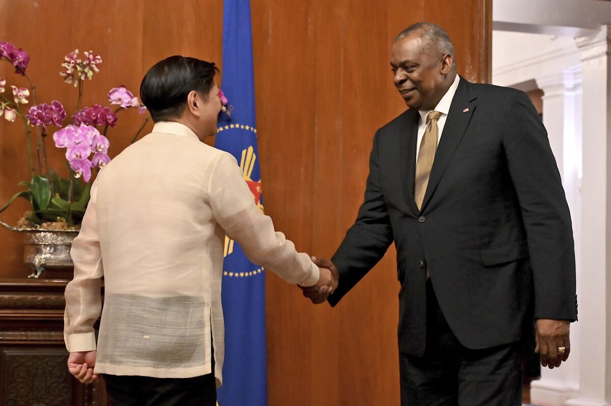 U.S. Secretary of Defense Lloyd James Austin III shakes hands with Philippine President Ferdinand Marcos Jr. on Thursday. 