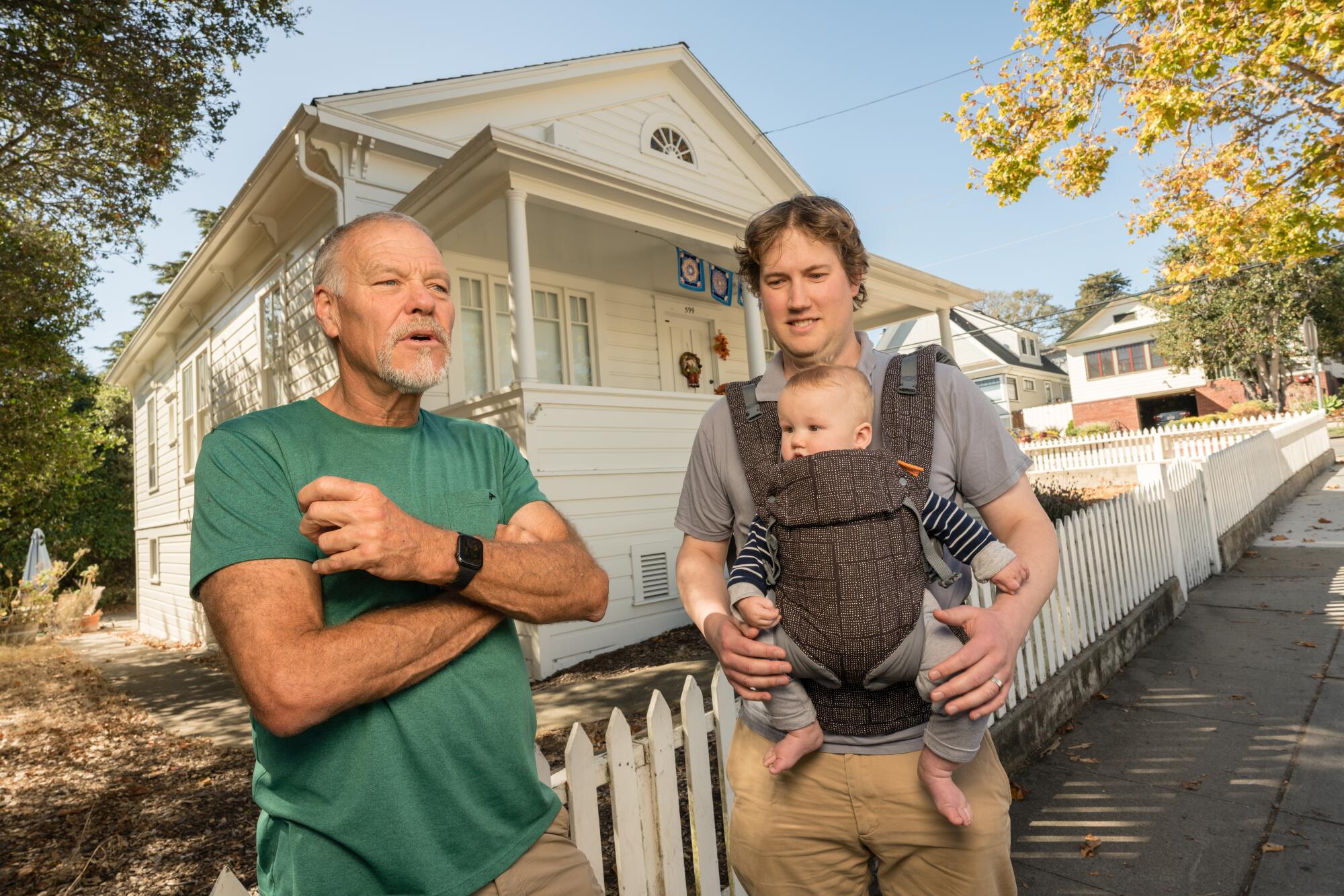 Thad Sigourney, left, Rob Schroeder, his son Remy, stand in front of a Monterey home given to the state by Sigourney's family
