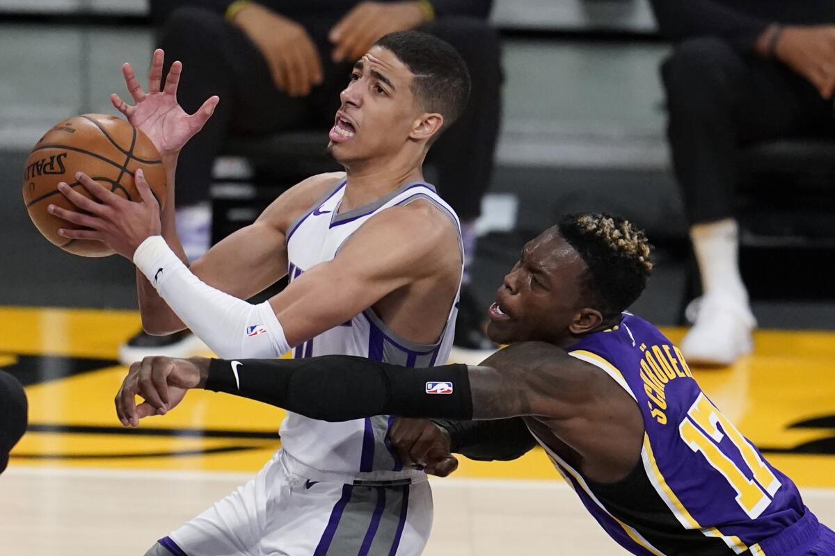 Lakers guard Dennis Schroder tries to knocks the ball from the grasp of Kings guard Tyrese Haliburton.
