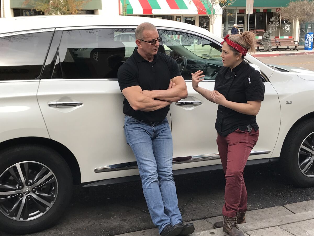 Chef Robert Irvine talks with Rosie's Cafe owner Kaitlyn Rose outside her downtown Escondido restaurant during filming of the Food Network series "Restaurant Impossible" in January 2019.