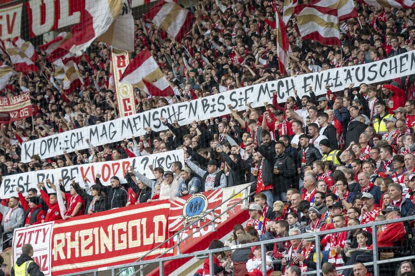 Aficionados del Mainz sostienen pancartas criticando al exjugador del equipo Jürgen Klopp en el encuentro de la Bundesliga ante el Leipzig el sábado 19 de octubre del 2024. (Torsten Silz/dpa via AP)