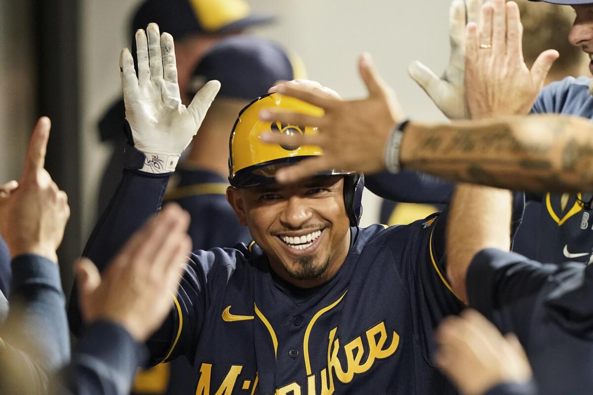 Milwaukee Brewers' Eduardo Escobar celebrates with teammates after hitting a solo home run in the sixth inning of a baseball game against the Cleveland Indians, Friday, Sept. 10, 2021, in Cleveland. (AP Photo/Tony Dejak)