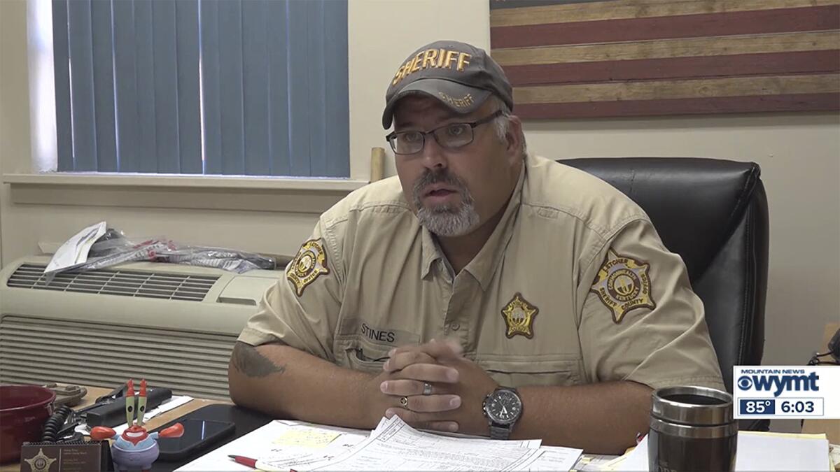  Sheriff Shawn Stines, in uniform, seated at a desk with his hands folded