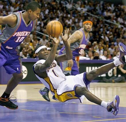 Laker guard Smush Parker slips and falls in front of the Suns' Leandro Barbosa.