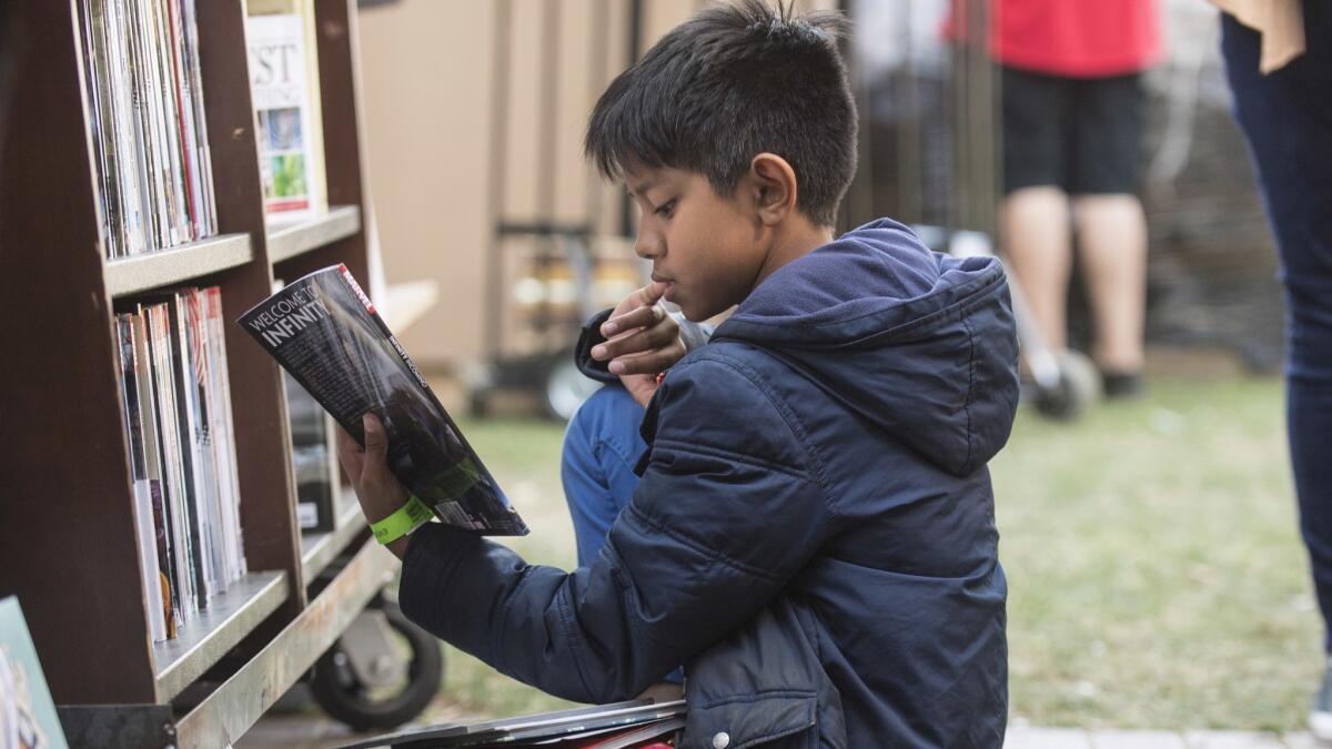 Winston Ordona 11, finds a book of interest at the Los Angeles Times Festival of Books on Sunday at USC.