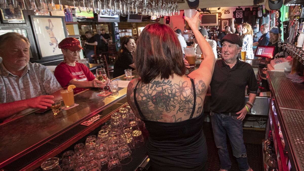 Chanda Heinz and Gary Monahan hoist an Irish rootbeer in a toast to Skosh Monahan's on Monday.