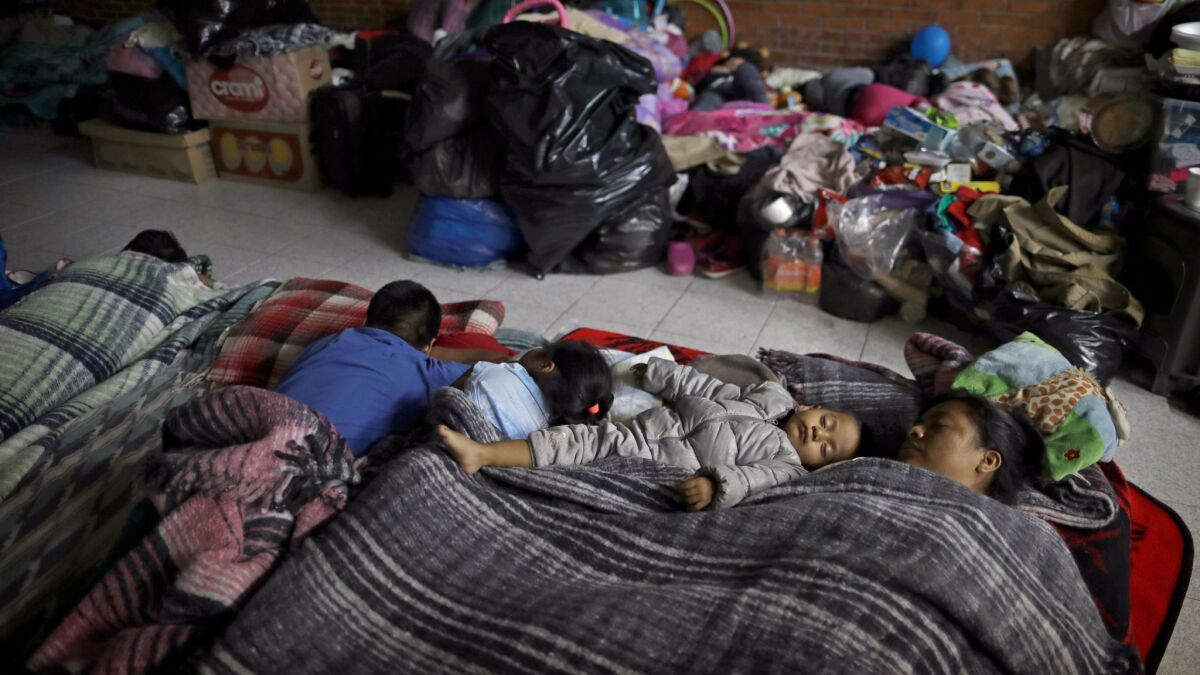 A family sleeps in a shelter after having been evacuated from their apartment in a large complex in Mexico City's Tlalpan neighborhood.