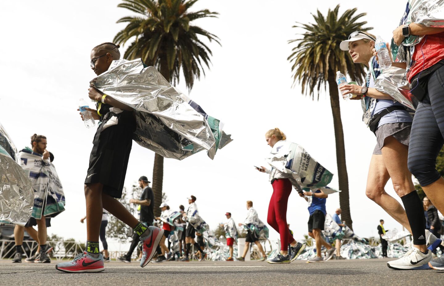 Runners warm up after finishing the L.A. Marathon in Santa Monica on Sunday.
