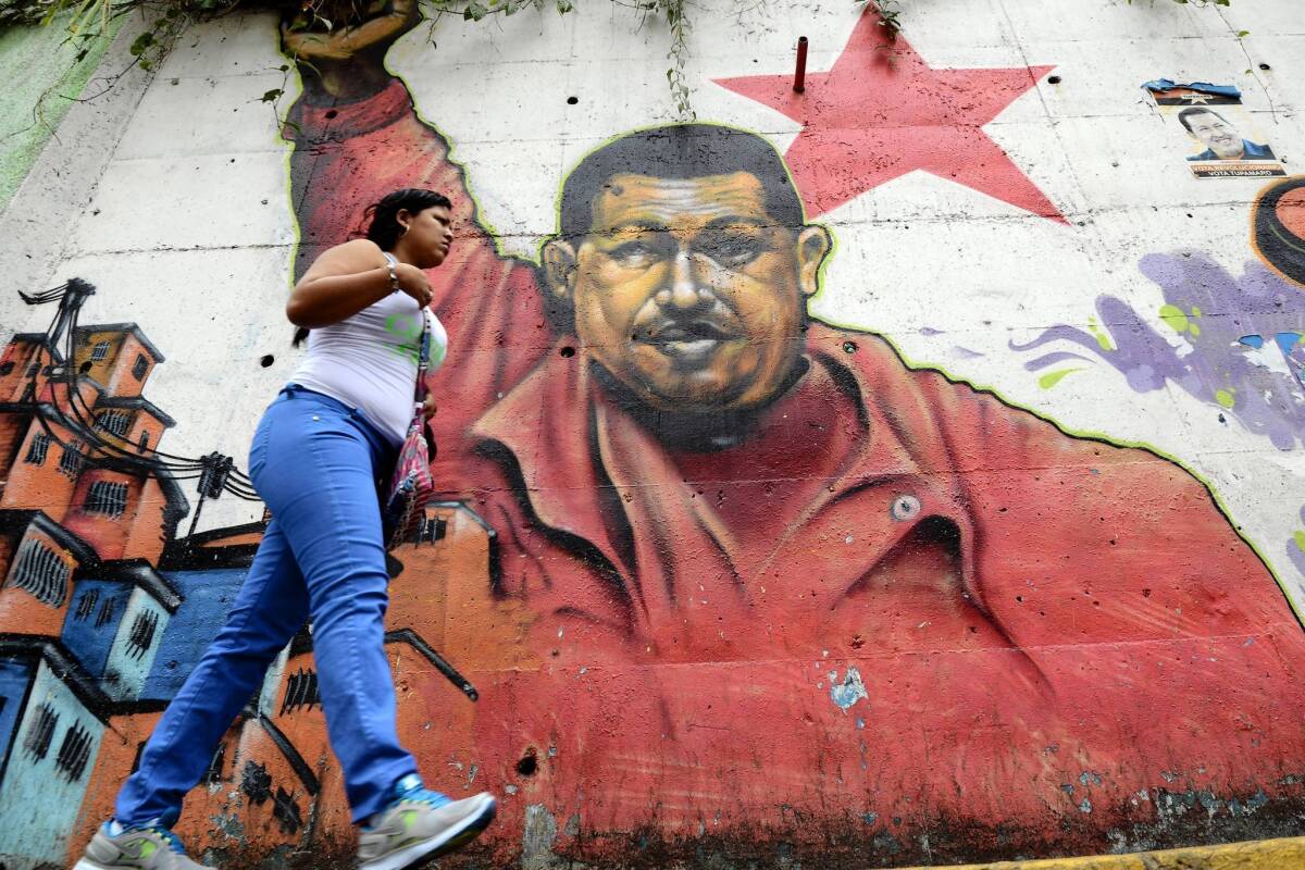 A woman walks past a mural of Venezuelan President Hugo Chavez in Caracas, the capital, this week.