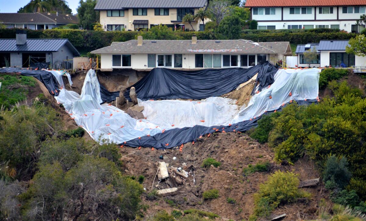 The hillside behind a home at 1930 Galaxy Drive in Newport Beach were covered Sunday in anticipation of further rain damage. 