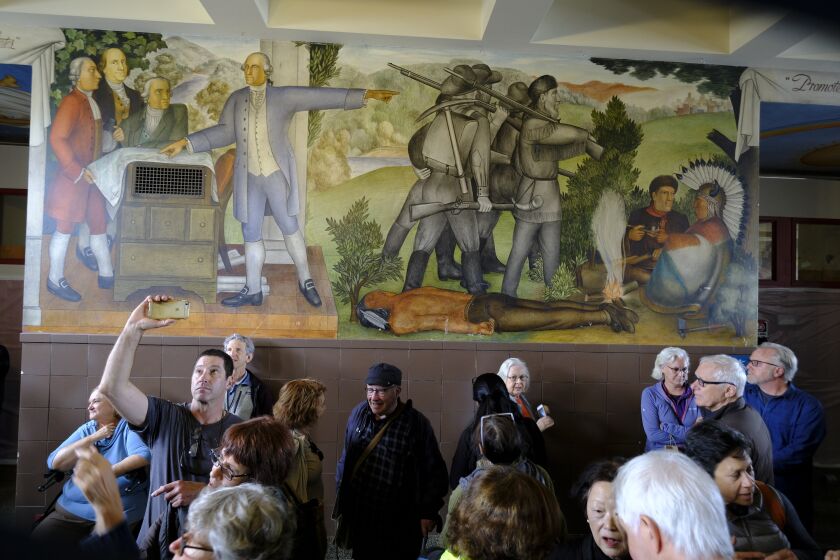 FILE - In this Aug. 1, 2019, file photo, people fill the main entryway of George Washington High School to view the controversial 13-panel, 1,600-square foot mural, the "Life of Washington," during an open house for the public in San Francisco. San Francisco Unified School District Board of Education President Stevon Cook says he plans to introduce a solution at the school board meeting Tuesday, August 13, 2019 to cover the "Life of Washington" mural without destroying it.. (AP Photo/Eric Risberg, File)