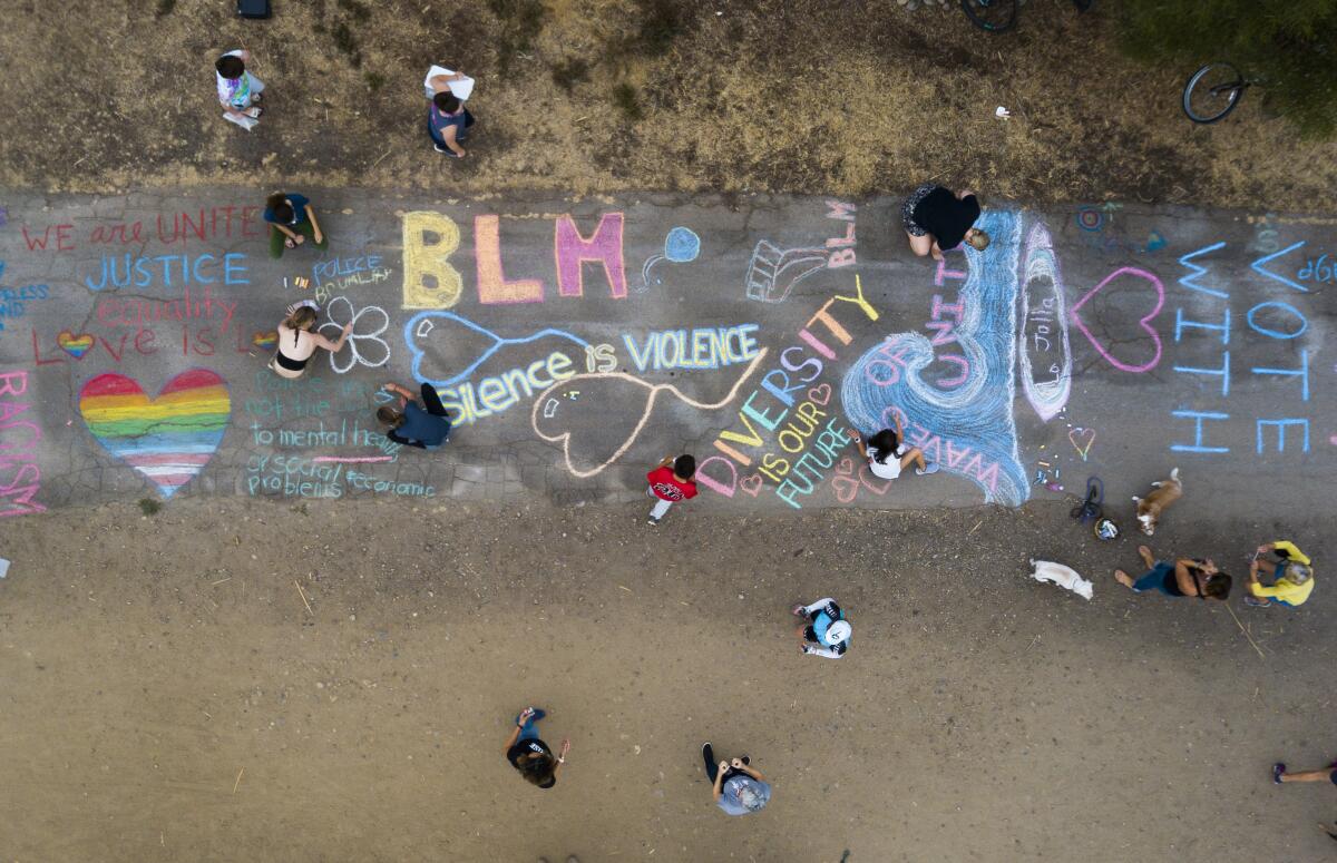 A group of parents and children from La Jolla gathered to write messages in chalk art in La Jolla.