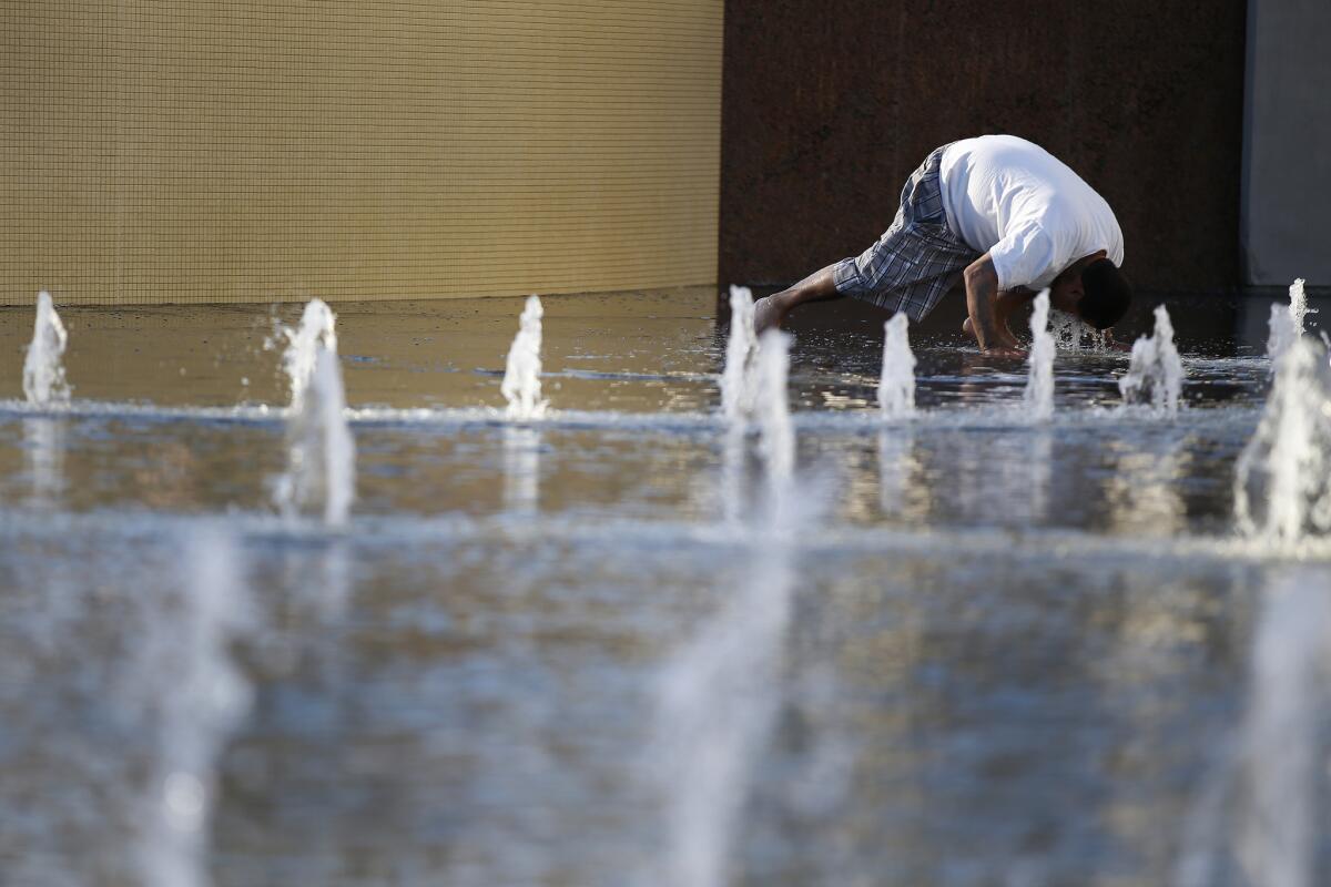 Greg Lewis of San Gabriel cools off in the fountain at Grand Park on a sunny afternoon.