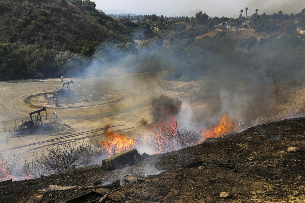 A wildfire burns near oil derricks in Yorba Linda.