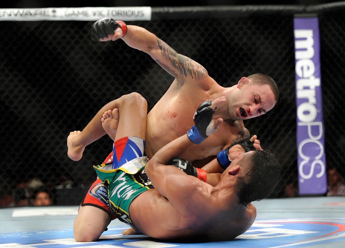 Frankie Edgar, left, punches Charles Oliveira during their featherweight fight at UFC 162 in Las Vegas on July 6, 2013.