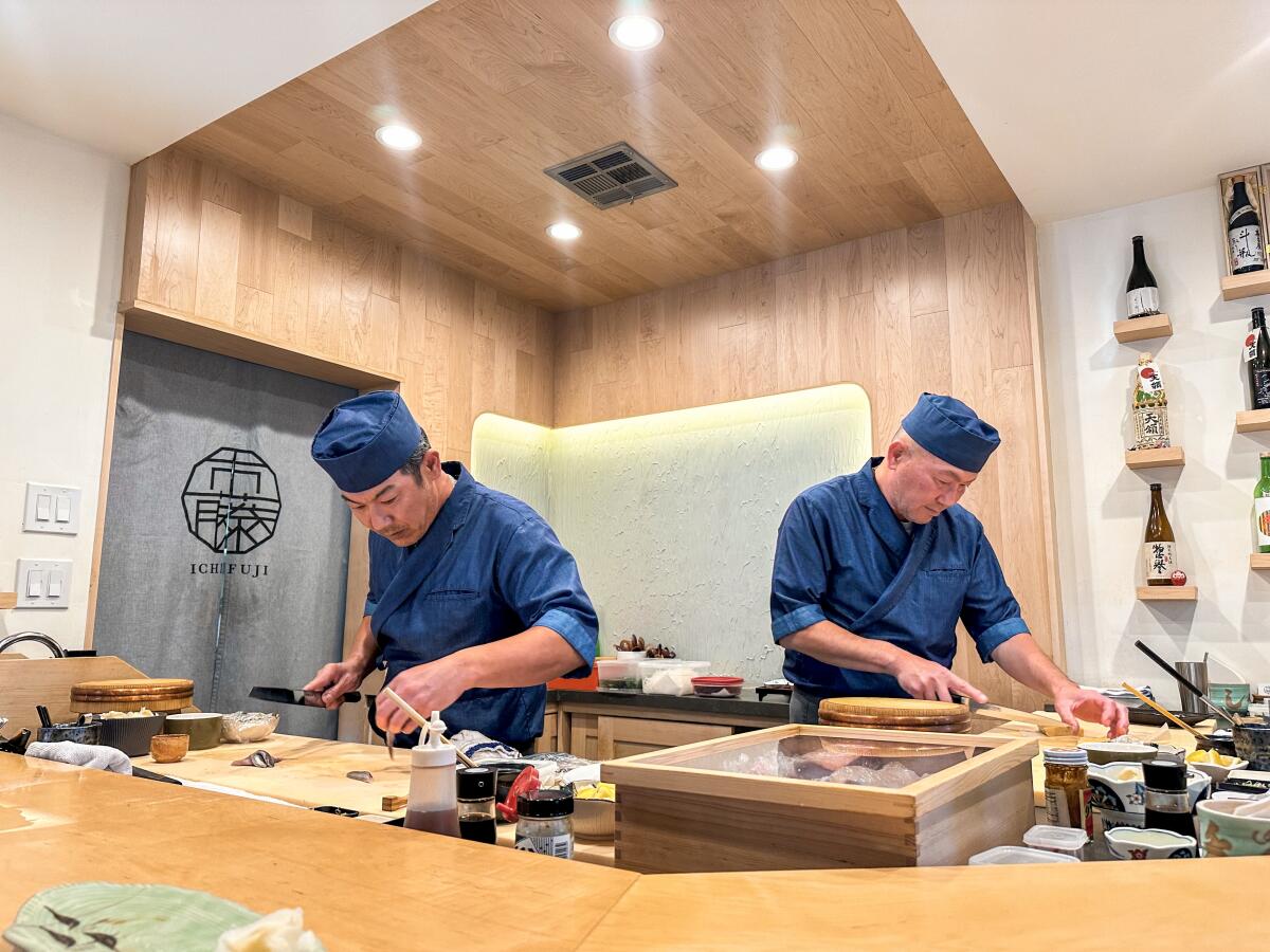 Chefs Hiroshi Ichikawa and Masato Fujita work at the bar of their San Diego sushi restaurant Ichifuji.