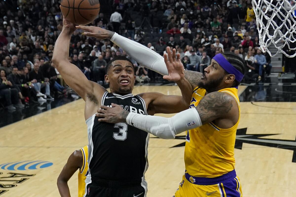 Spurs forward Keldon Johnson is fouled by Lakers forward Carmelo Anthony as he drives to the basket 
