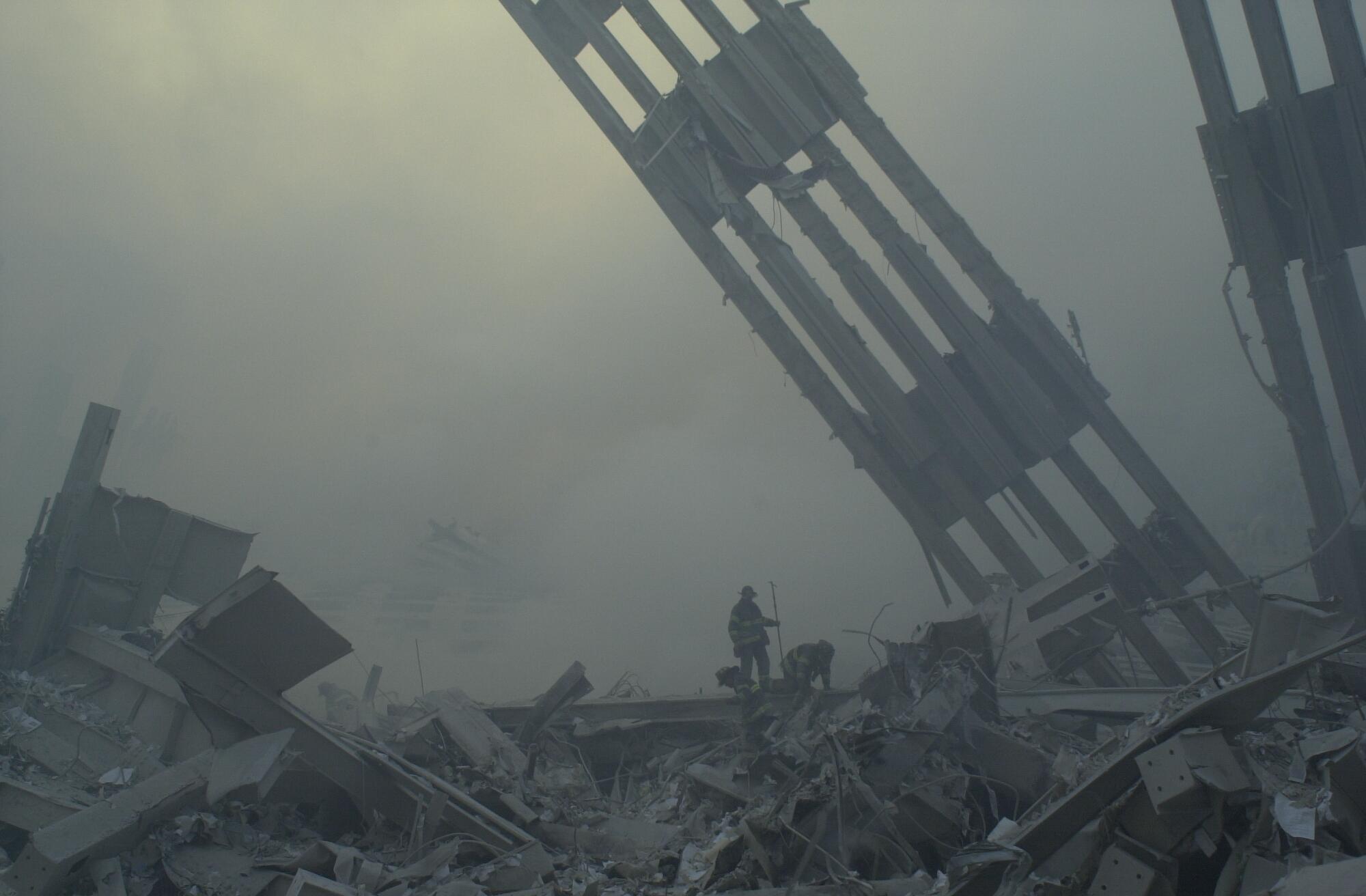 Firefighters are dwarfed by debris at the World Trade Center site