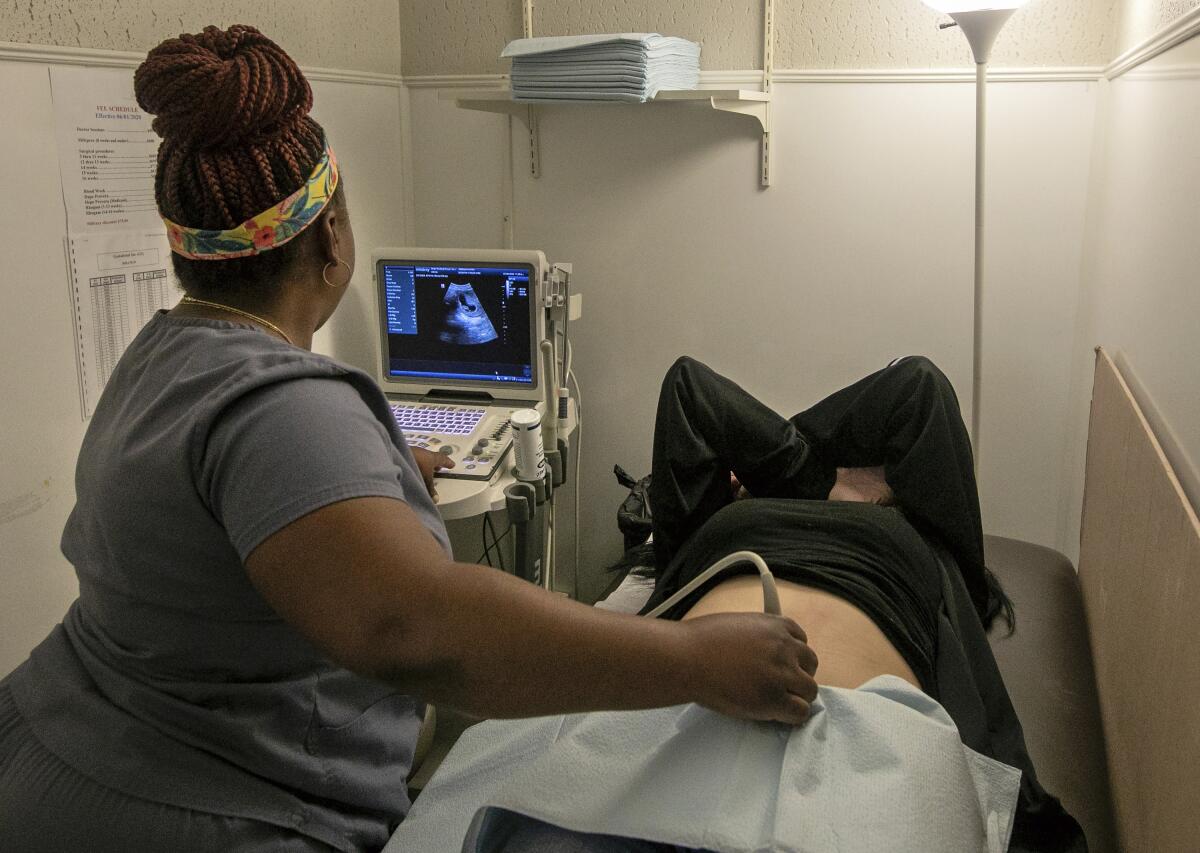 A medical technician performs an ultrasound on a patient